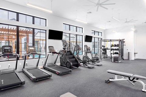 A gym with treadmills, elliptical machines, and other exercise equipment.