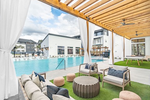 A modern outdoor living area with a pool and lounge chairs.