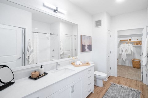 A white bathroom with a toilet, sink, and mirror.