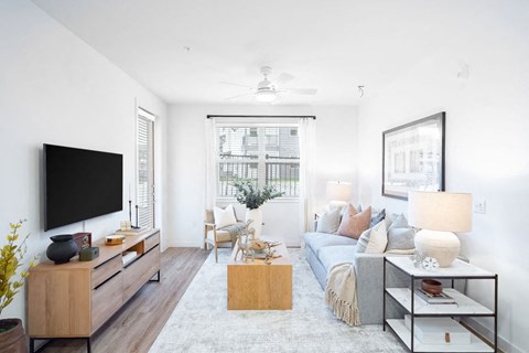 A modern living room with a flat screen TV, a sofa, and a coffee table.