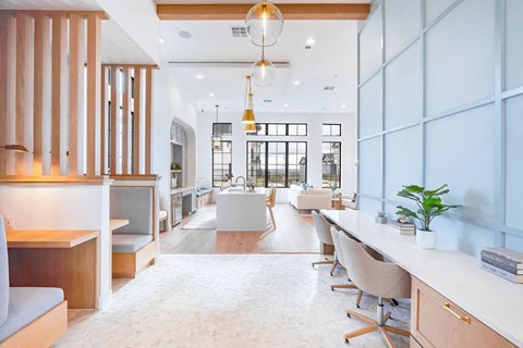 A modern office space with a long white table and chairs.