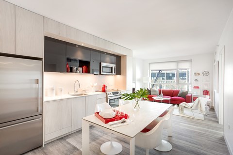 San Francisco Luxury Apartments - Trinity PLace at 33 8th - Brightly-Lit Open Kitchen with Stainless Steel Appliances, White Lower Cabintry, White Countertops, Black Overhead Cabinets, and Art