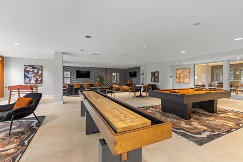 A modern living room with a long wooden table in the center.