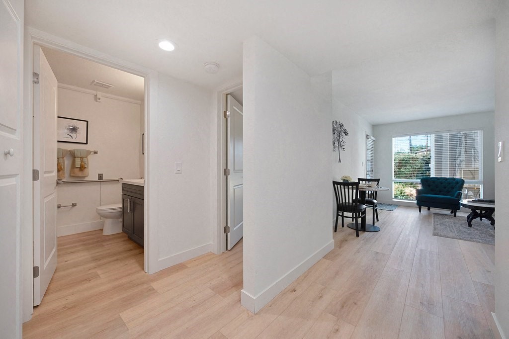a bedroom with a medium sized bed and a chair in a room with a sink and a at The Crest at Citrus Heights Apartments, Citrus Heights, California