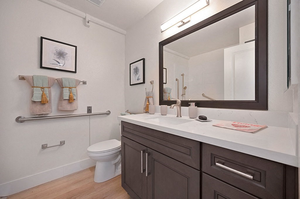a bathroom with a white countertop and a black mirror at The Crest at Citrus Heights Apartments, Citrus Heights