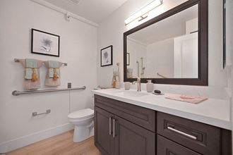 a bathroom with a white countertop and a black mirror a bathroom with a white countertop and a black mirror at The Crest at Citrus Heights Apartments, Citrus Heights