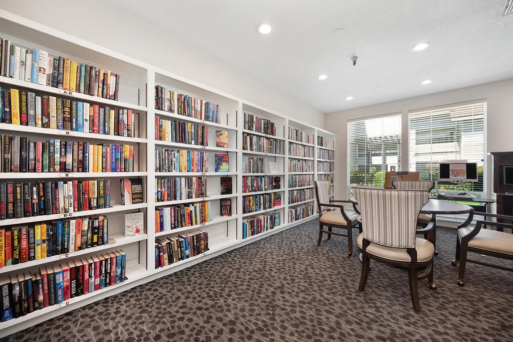 a library with bookshelves and a table and chairs