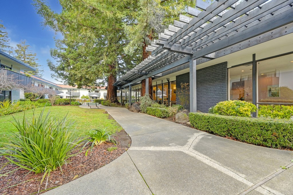a walkway in front of a building with a large glass window