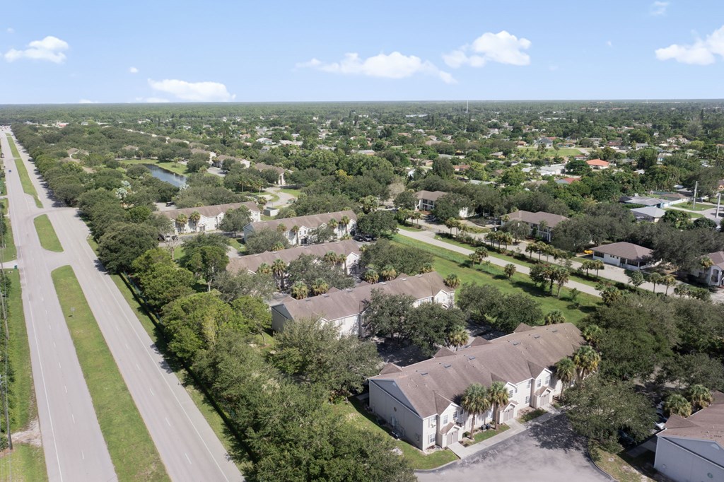 A road runs through a green suburban neighborhood.