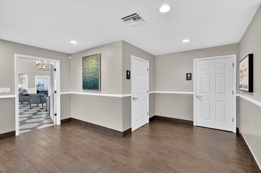 A spacious room with a wooden floor and white walls.