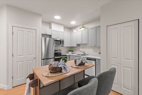 A modern kitchen with a dining table set for two.