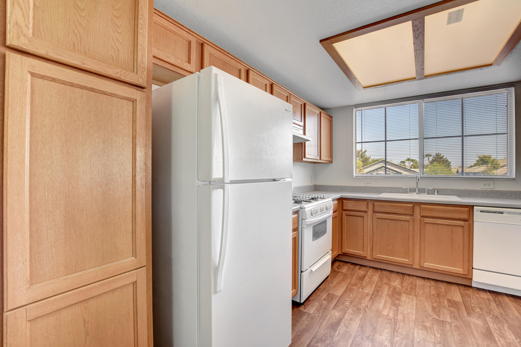 a kitchen with white appliances and wooden cabinets
