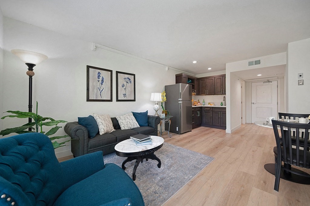a living room with blue couches and a coffee table  at The Crest at Citrus Heights, California