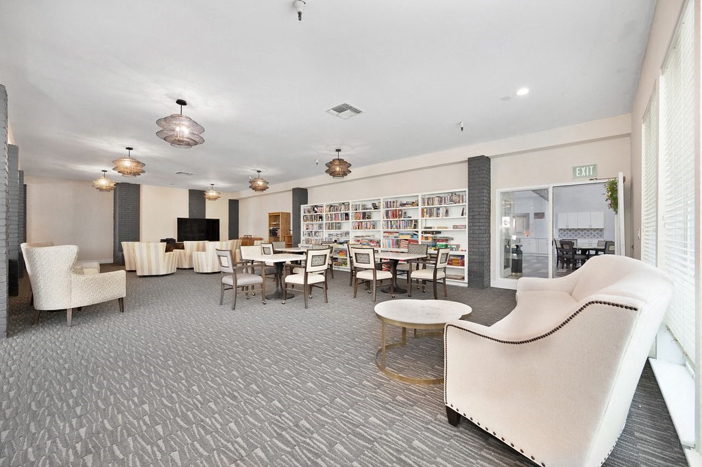 a lounge area with chairs tables and a television