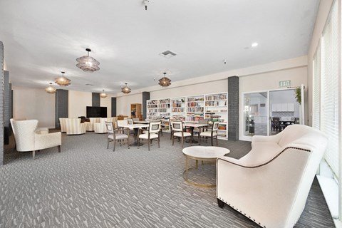 a lounge area with chairs tables and a television