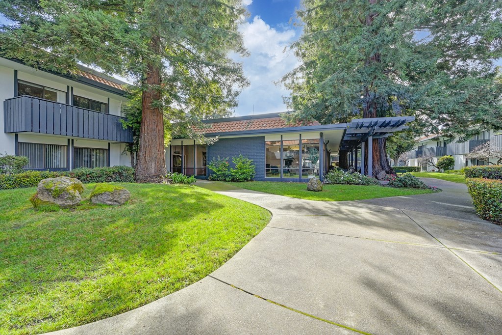 a sidewalk in front of a building with trees