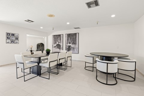 A white dining room with a table and chairs.