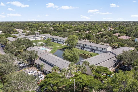 A bird's eye view of a resort with a swimming pool and a parking lot.
