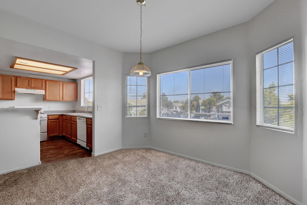 an empty living room and kitchen with a large window