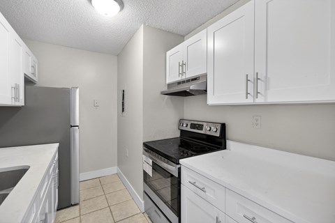 A kitchen with white cabinets and appliances.