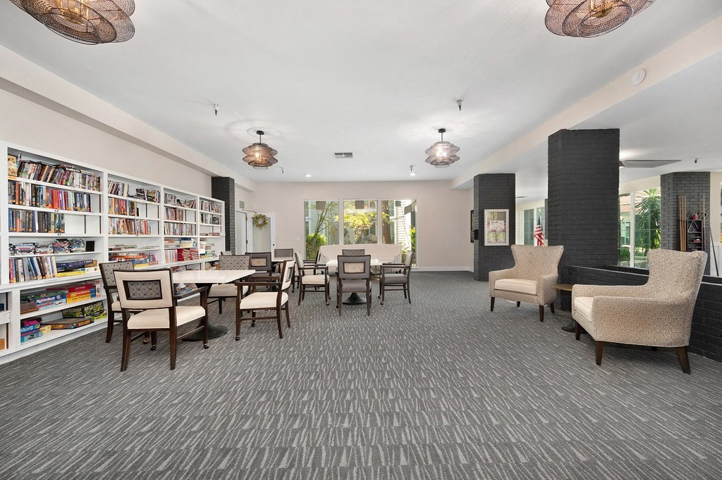 a common area with chairs tables and bookshelves