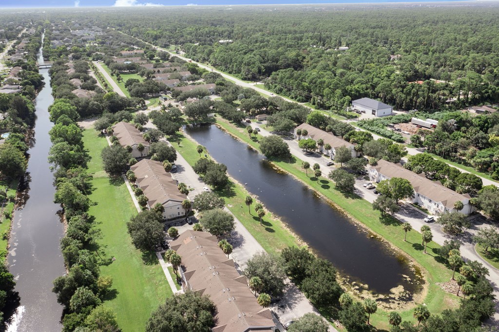 A river runs through a residential area with houses on both sides.