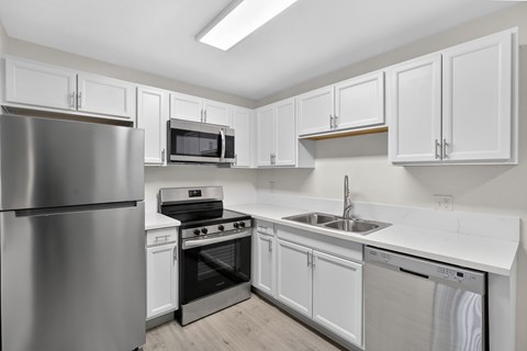 A kitchen with white cabinets and stainless steel appliances.