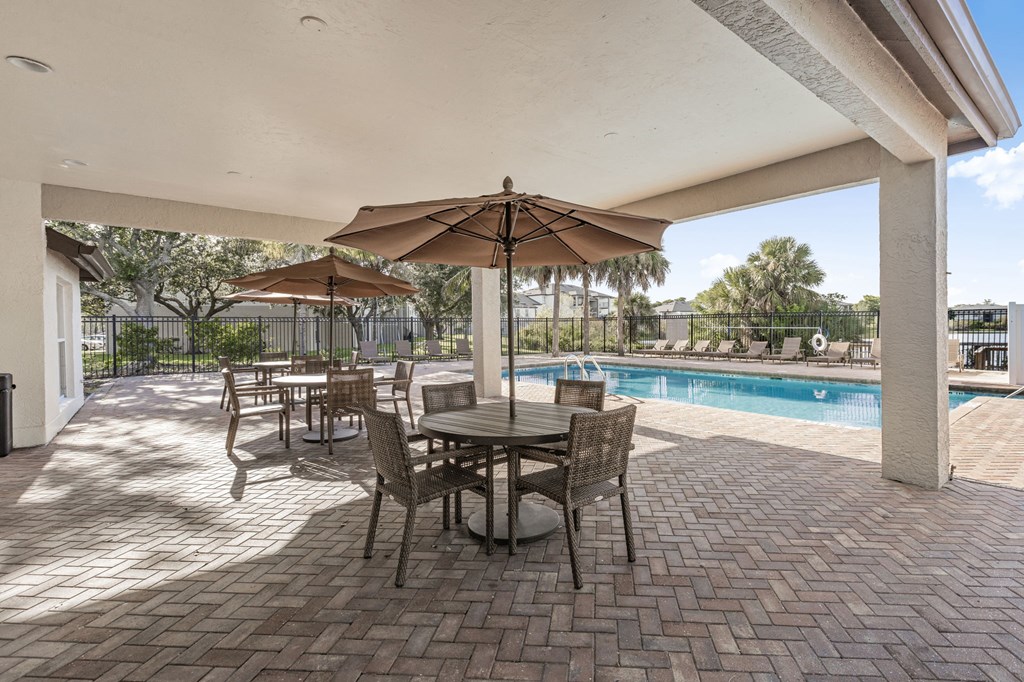 A patio with a table and chairs under an umbrella.