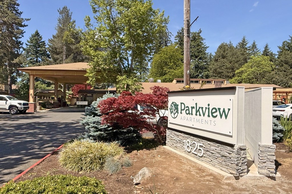 The image shows the entrance to Parkview Apartments with a sign and a landscaped area in front.