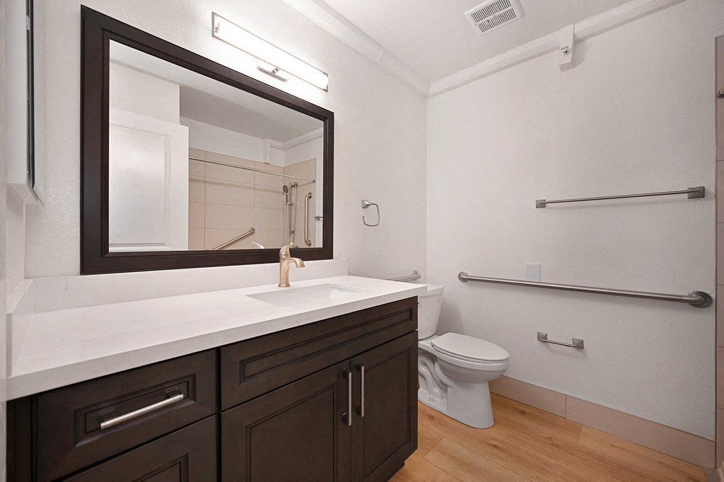 a bathroom with a toilet sink and mirror at Citrus Heights Apartments, California, 95621