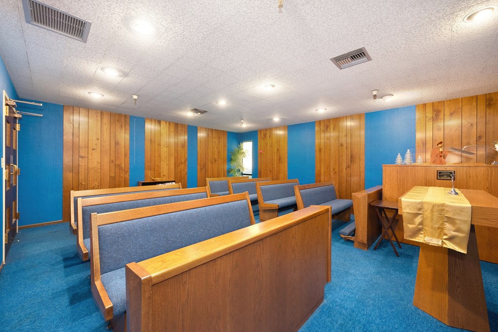 a conference room with blue walls and wooden benches