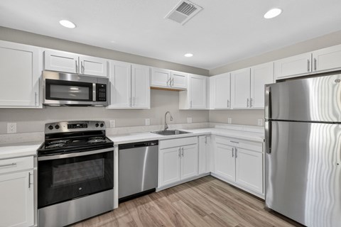 A kitchen with white cabinets and stainless steel appliances.