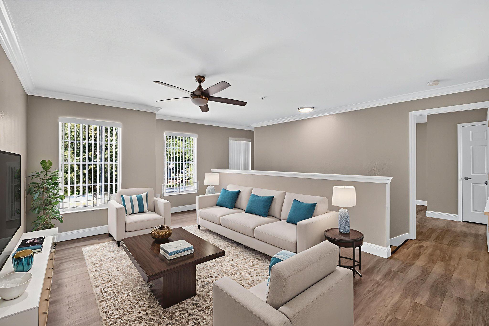 A living room with a white couch and a brown coffee table.