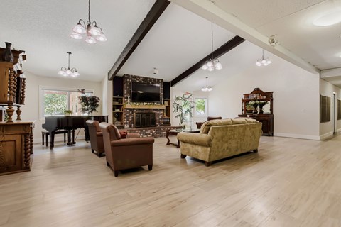 A living room with a piano, a couch, and a chair.