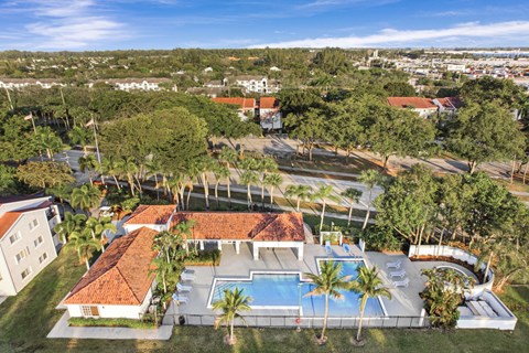 A large clubhouse with a pool in the backyard.