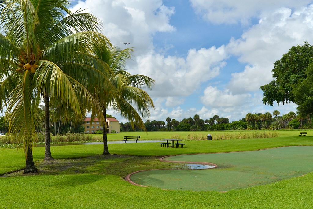 a golf course with two palm trees in a park