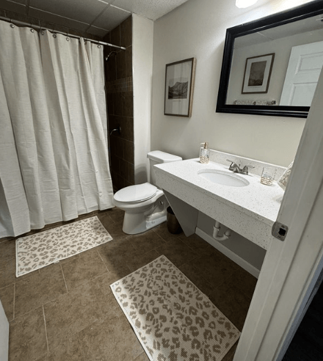 A bathroom with a toilet, sink, and shower curtain.