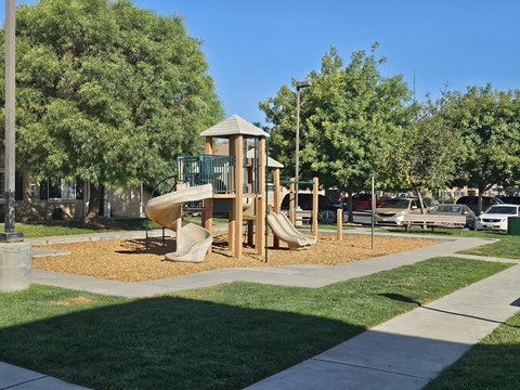 A playground with a wooden structure and a slide.