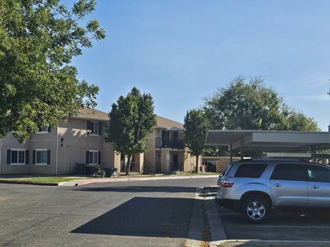 A silver SUV is parked in a parking lot in front of a building.