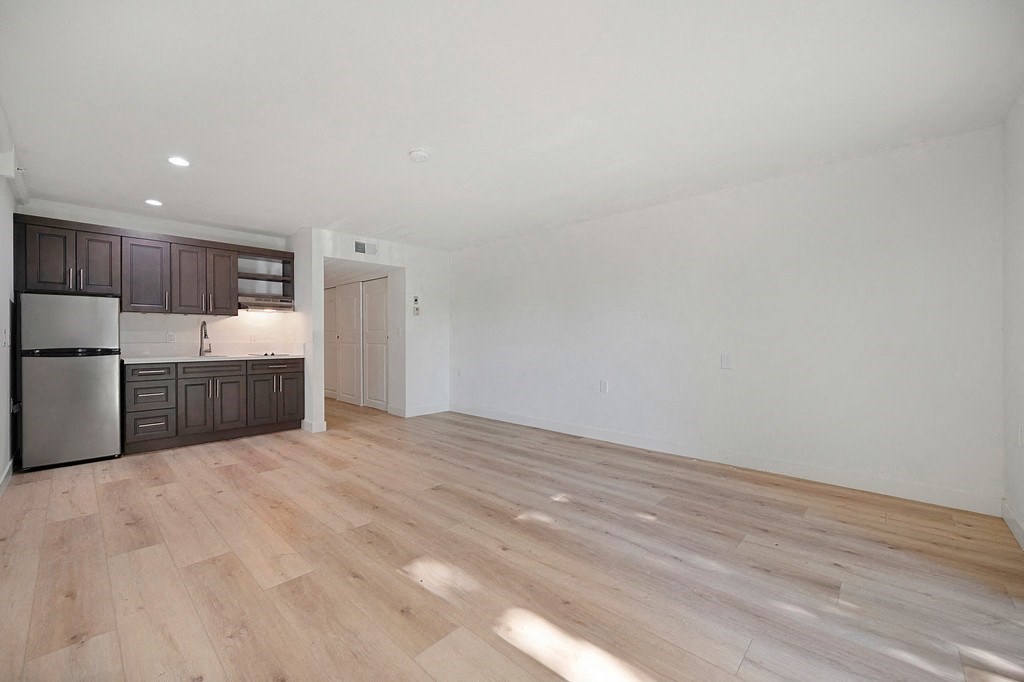 a kitchen and living room with white walls and hardwood floors at Citrus Heights Apartments, Citrus Heights, CA,95621