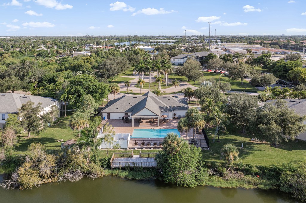 A house with a pool in the middle of a green field.