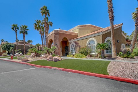 A house with a red curb and palm trees in front.