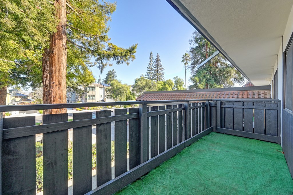 a backyard with a deck and green turf