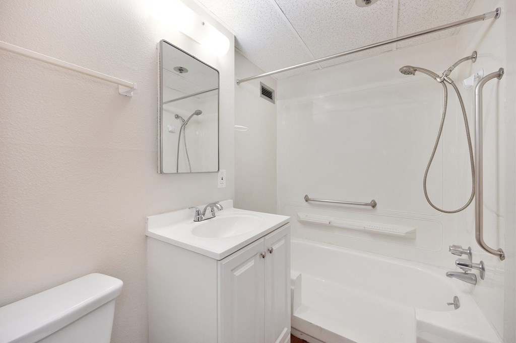 a white bathroom with a shower and a sink