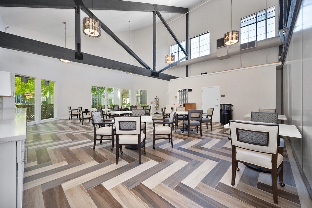 a large room with hardwood floors and a vaulted ceiling with exposed beams