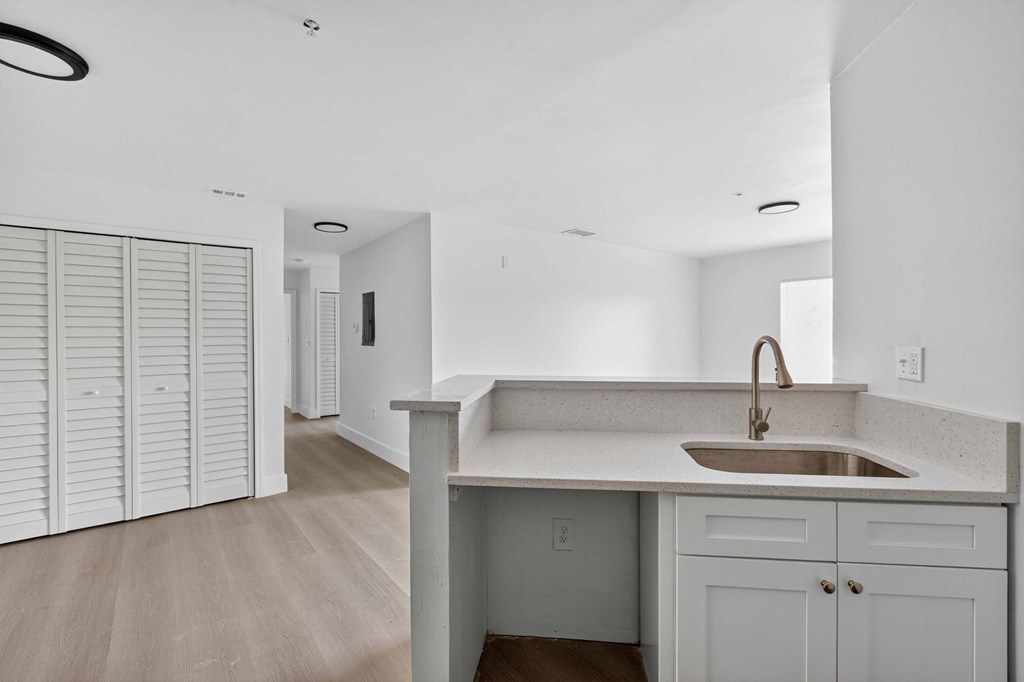 A kitchen with a sink and a white counter top.