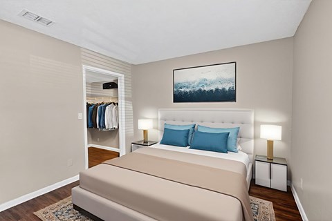 A bedroom with a large bed and a painting on the wall.