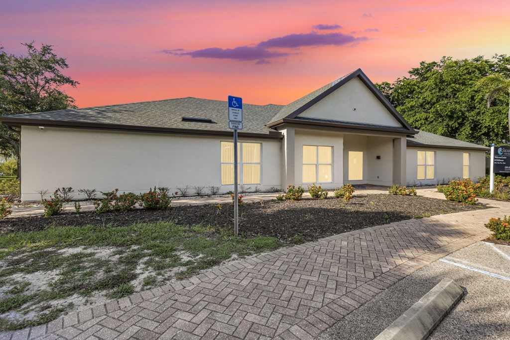 A house with a driveway and a sign in front of it.