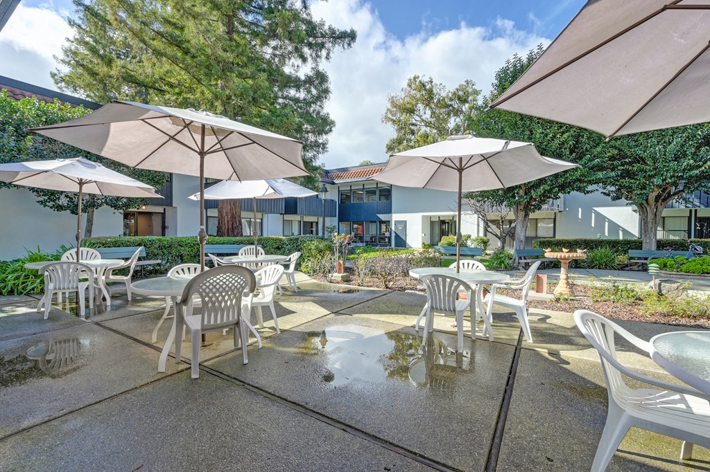 a patio with tables and chairs and umbrellas
