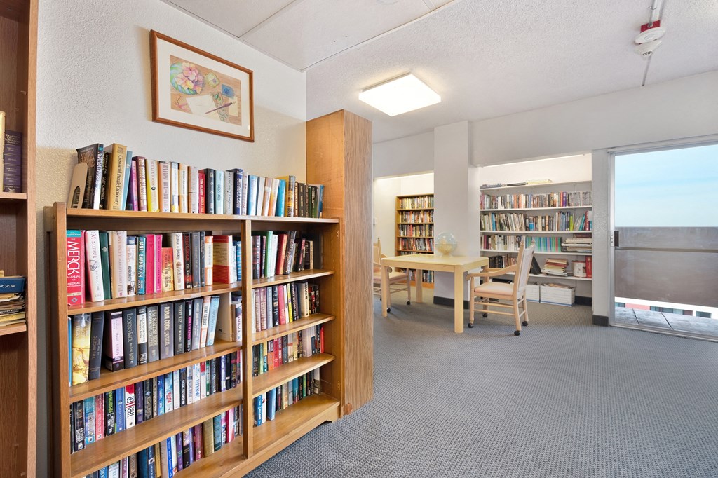 a room filled with bookshelves and a table with chairs